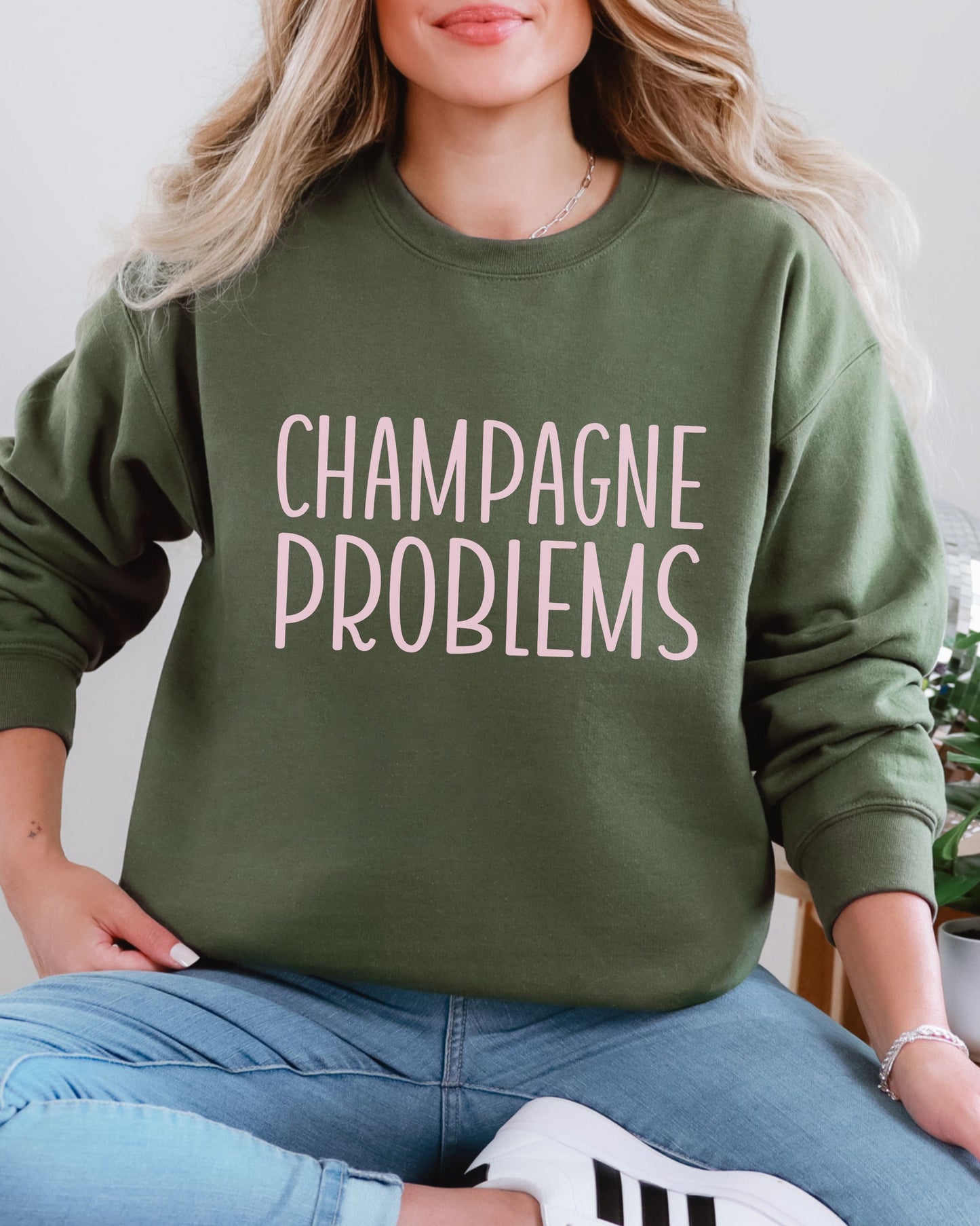 Person wearing a green sweatshirt with 'CHAMPAGNE PROBLEMS' text.