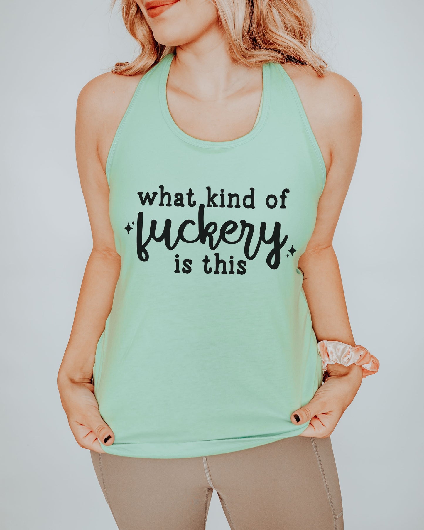 Person wearing a mint green tank top with text on a plain background