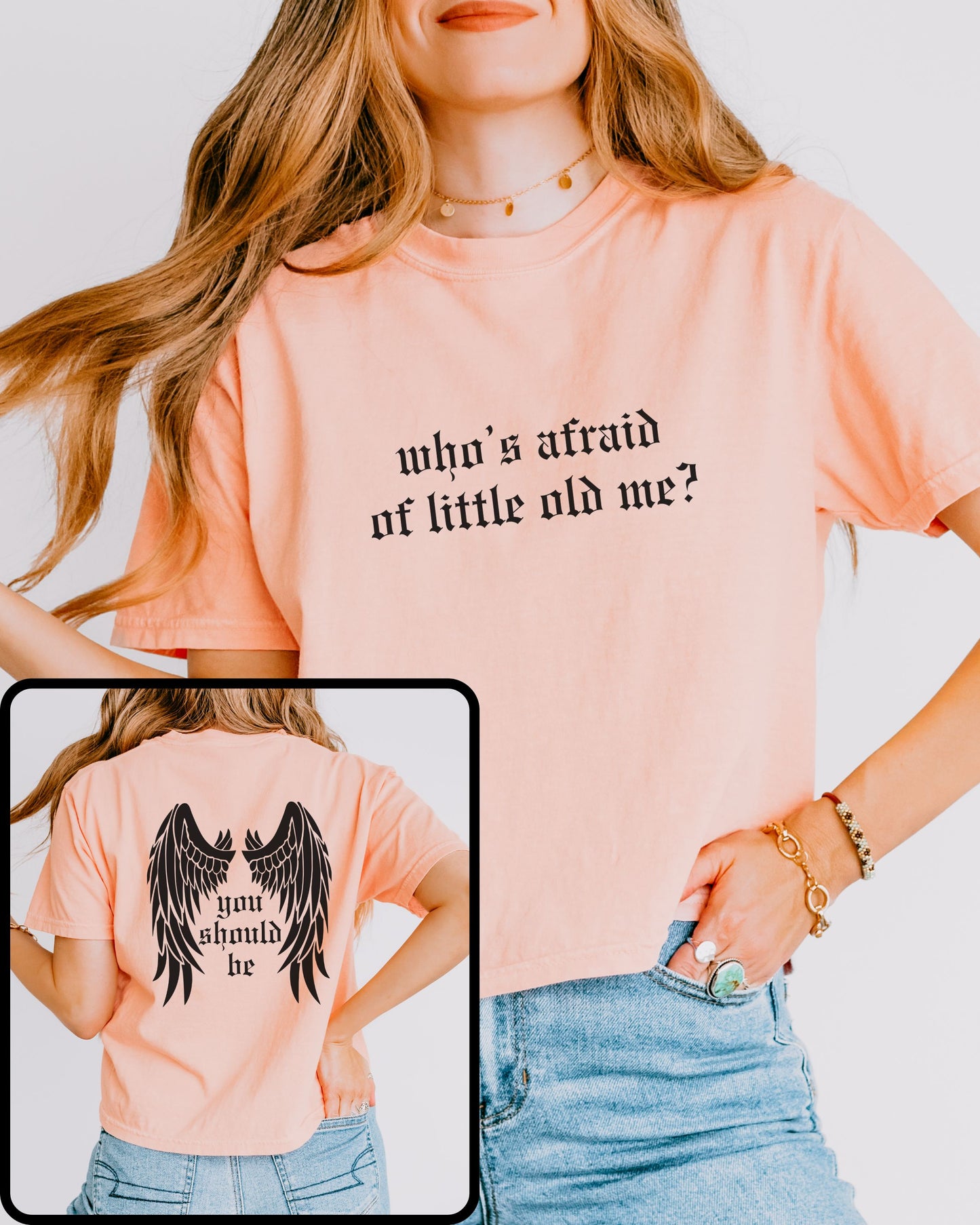 woman wearing comfort colors crop top in peach with who’s afraid of little old me text on front and wings with you should be on back