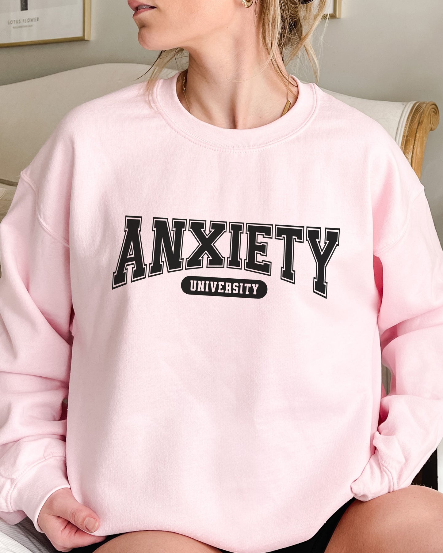 Person wearing a pink sweatshirt with 'ANXIETY UNIVERSITY' text.