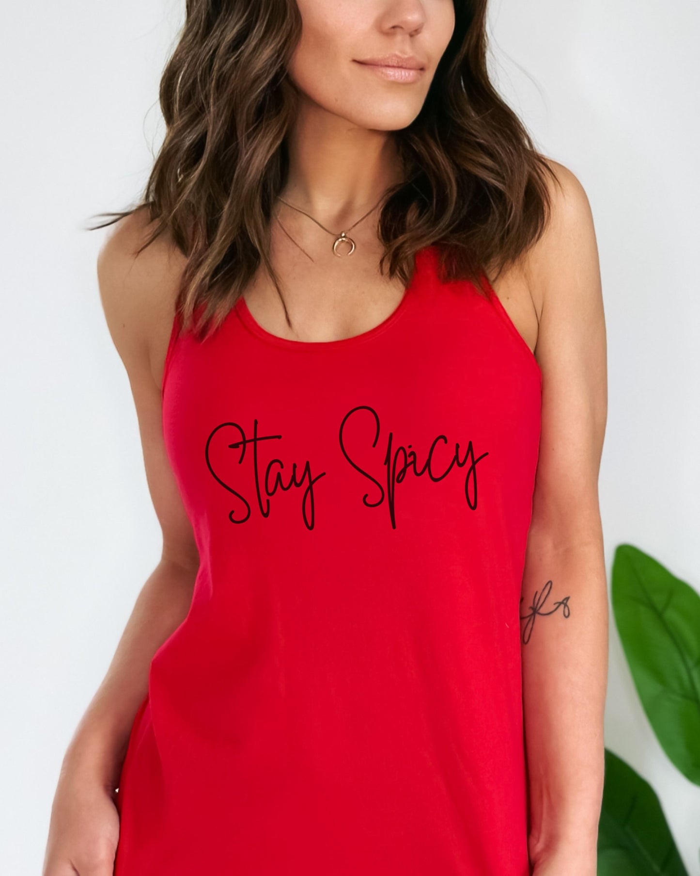 Person wearing a red tank top with 'Stay Spicy' text on a white background