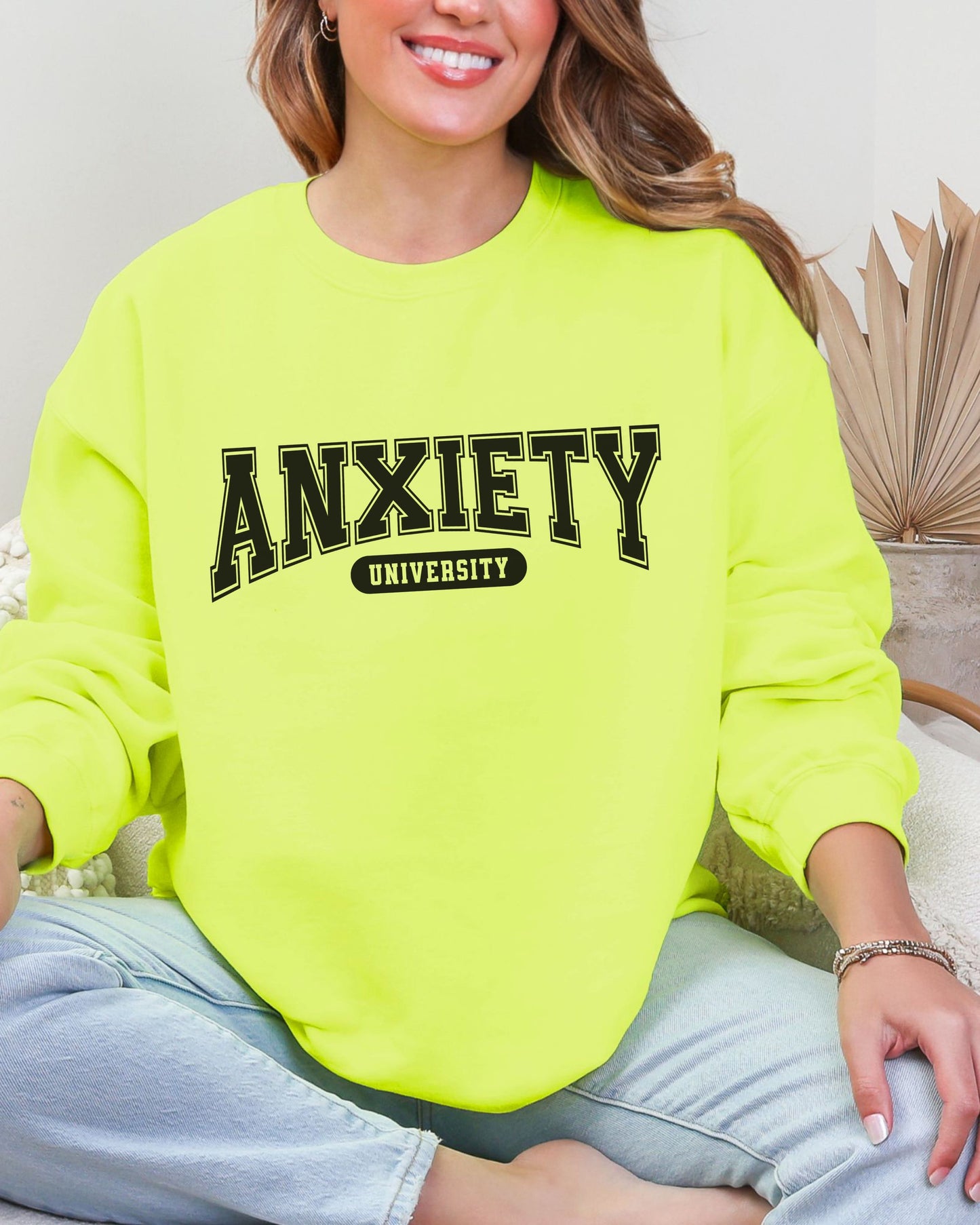 Person wearing a neon green sweatshirt with 'ANXIETY UNIVERSITY' text.