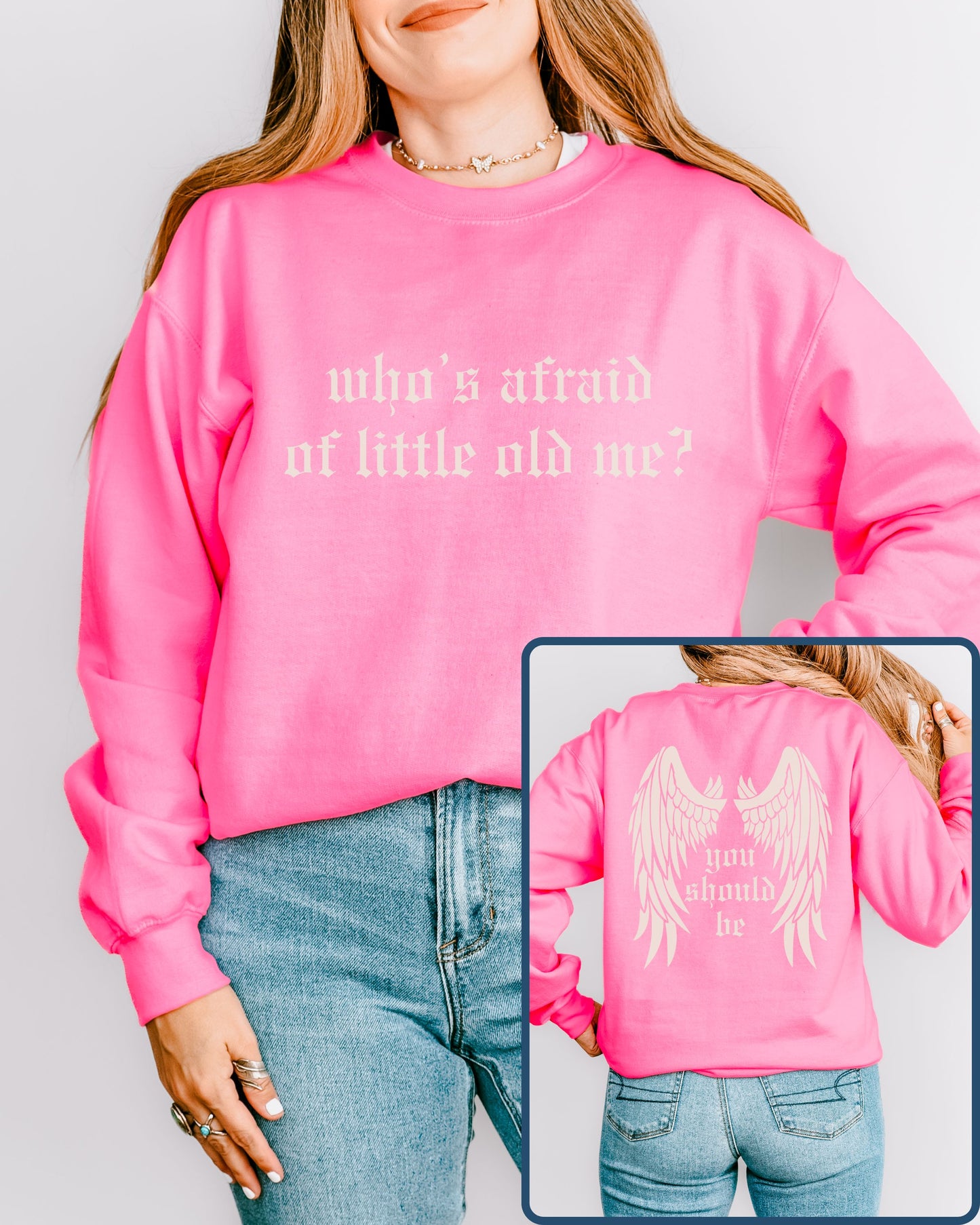 Person wearing a pink sweatshirt with text and an angel wings design on the back, against a plain background.
