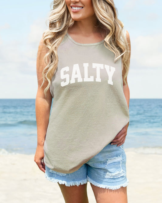 Woman wearing a tank top with 'SALTY' on a beach