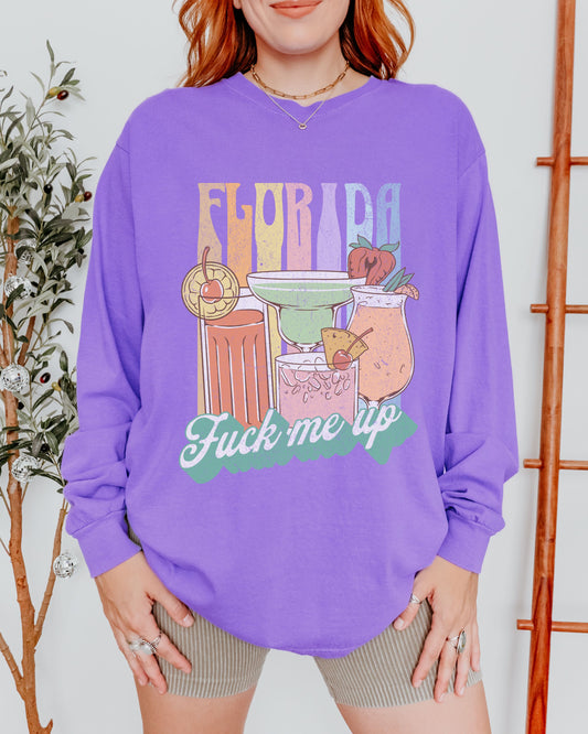 Person wearing a purple sweatshirt with a graphic design and text.