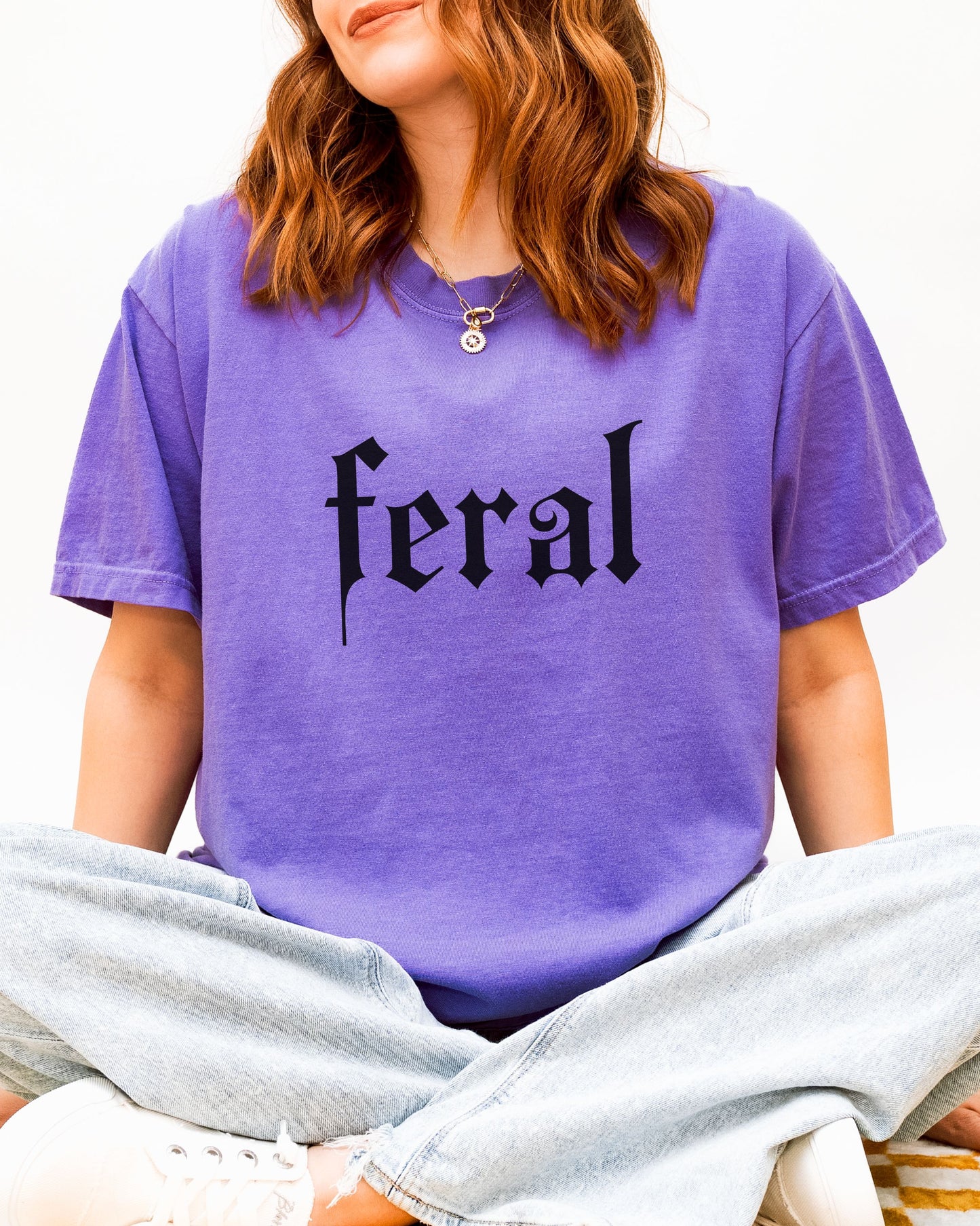 grunge aesthetic feral t-shirt in black font worn by model, in color violet