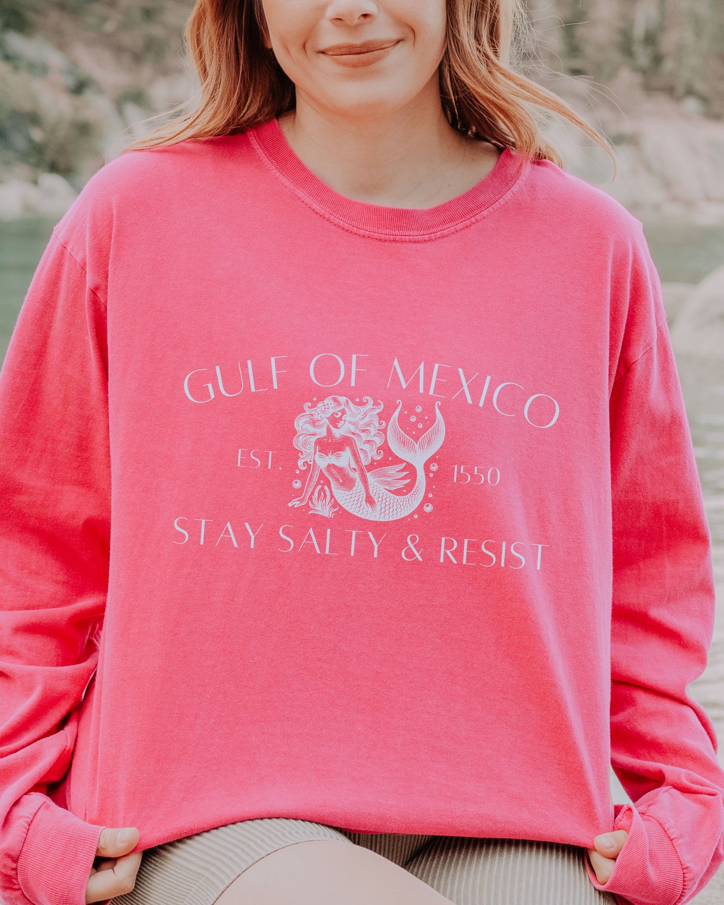 Person wearing a pink sweatshirt with 'Gulf of Mexico' and 'Stay Salty & Resist' text.