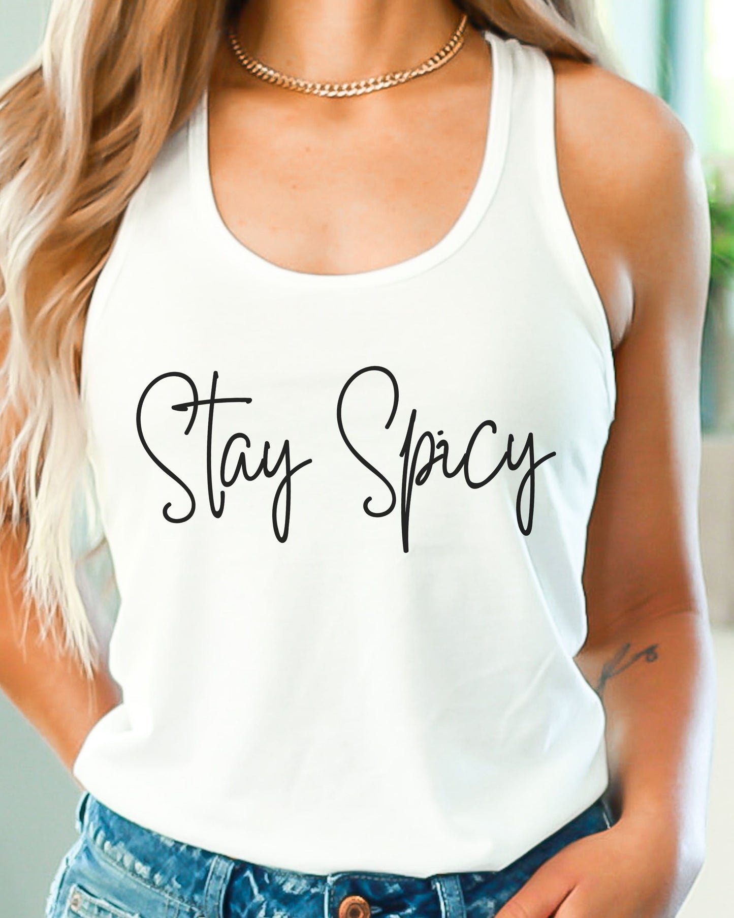 White tank top with 'Stay Spicy' text worn by a person.