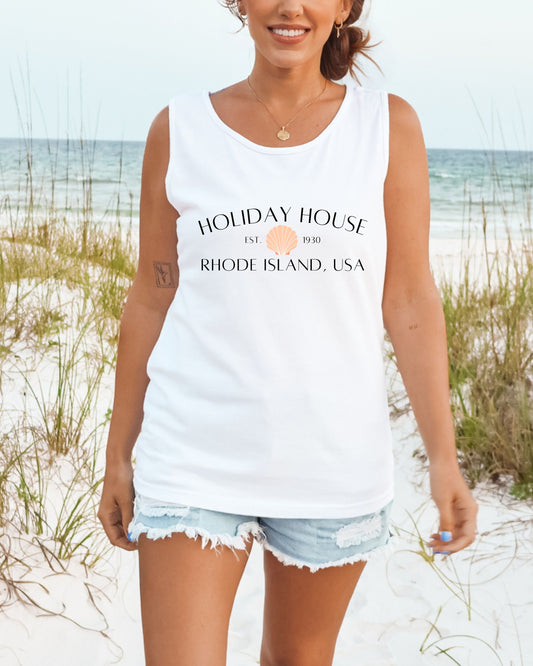 Woman wearing a white tank top with 'Holiday House' text on a beach
