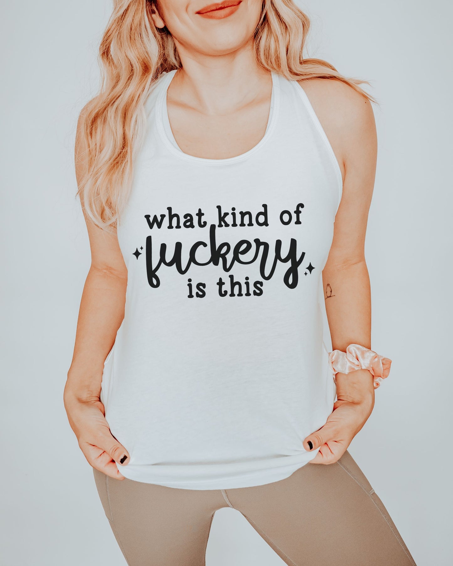 Person wearing a white tank top with black text on a plain background