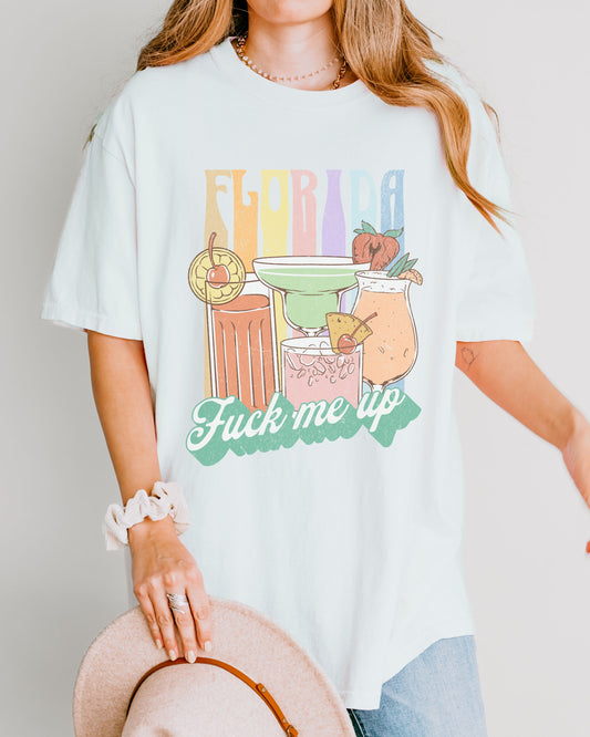 Person wearing a white t-shirt with colorful graphic and text.