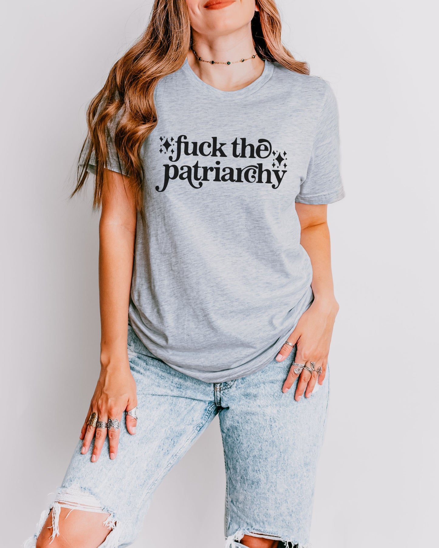 woman wearing a athletic heather fuck the patriarchy shirt, feminist graphic tee