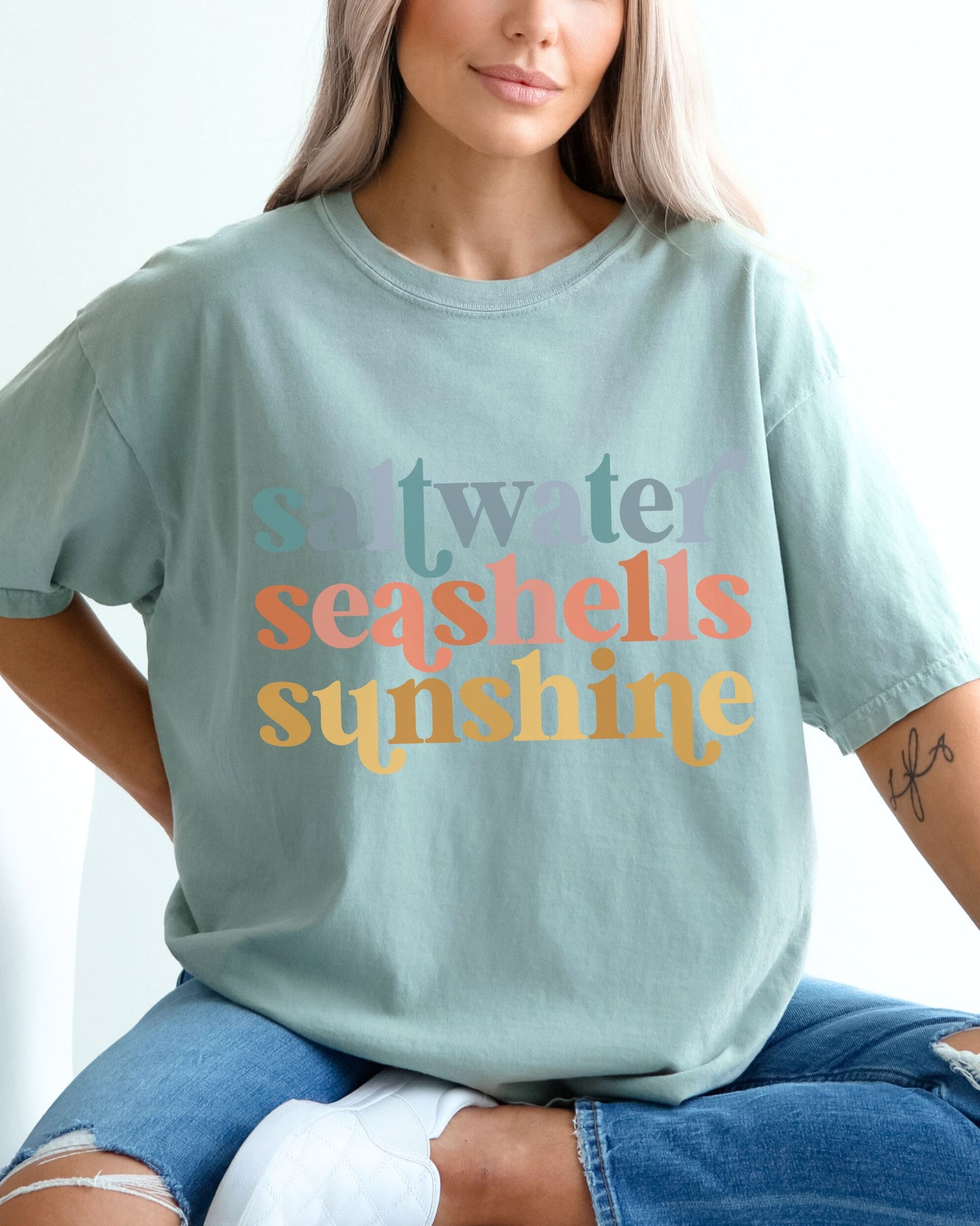 woman wearing beach vibes shirt with saltwater seashells sunshine design