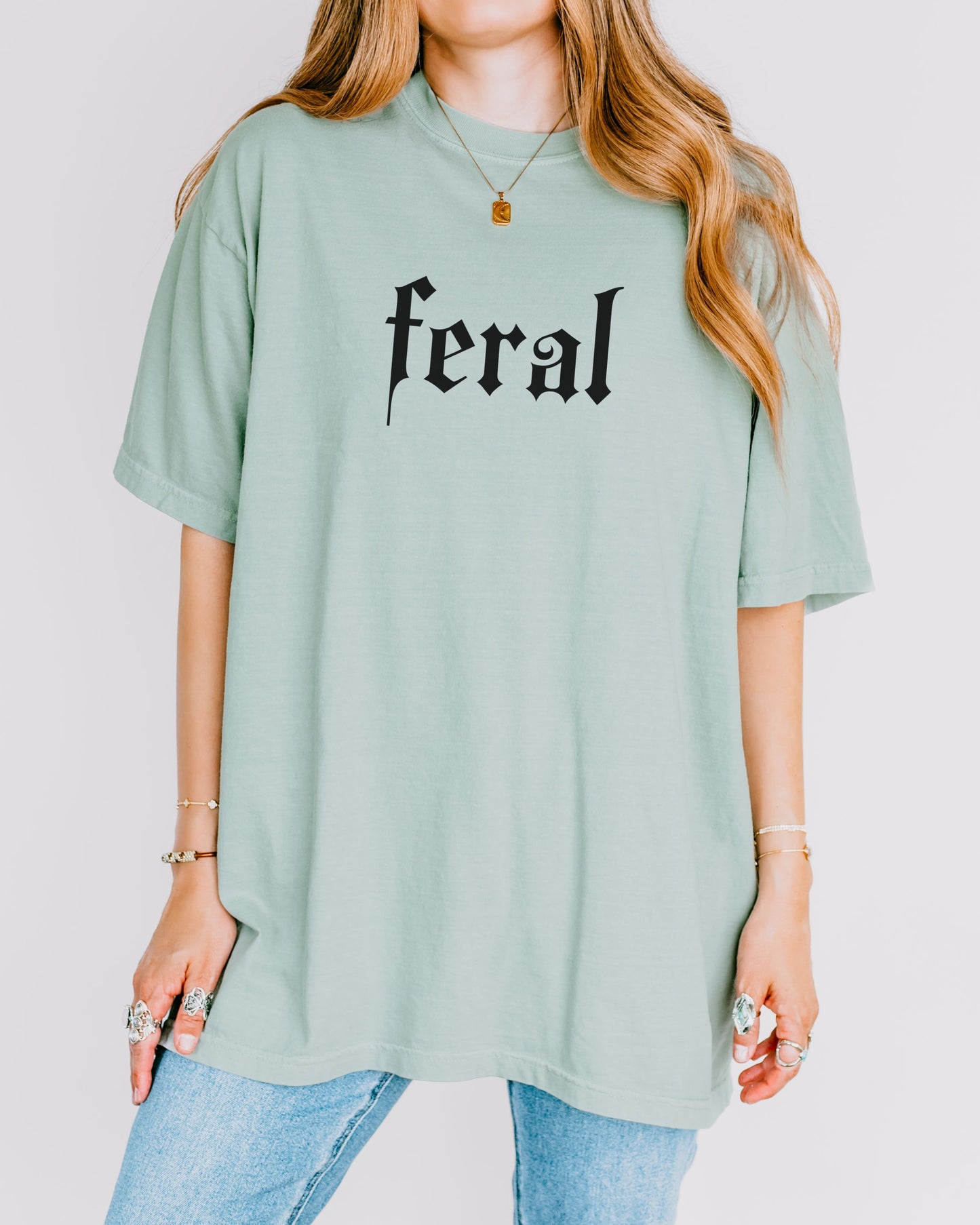 grunge aesthetic feral t-shirt in black font worn by model, in color bay