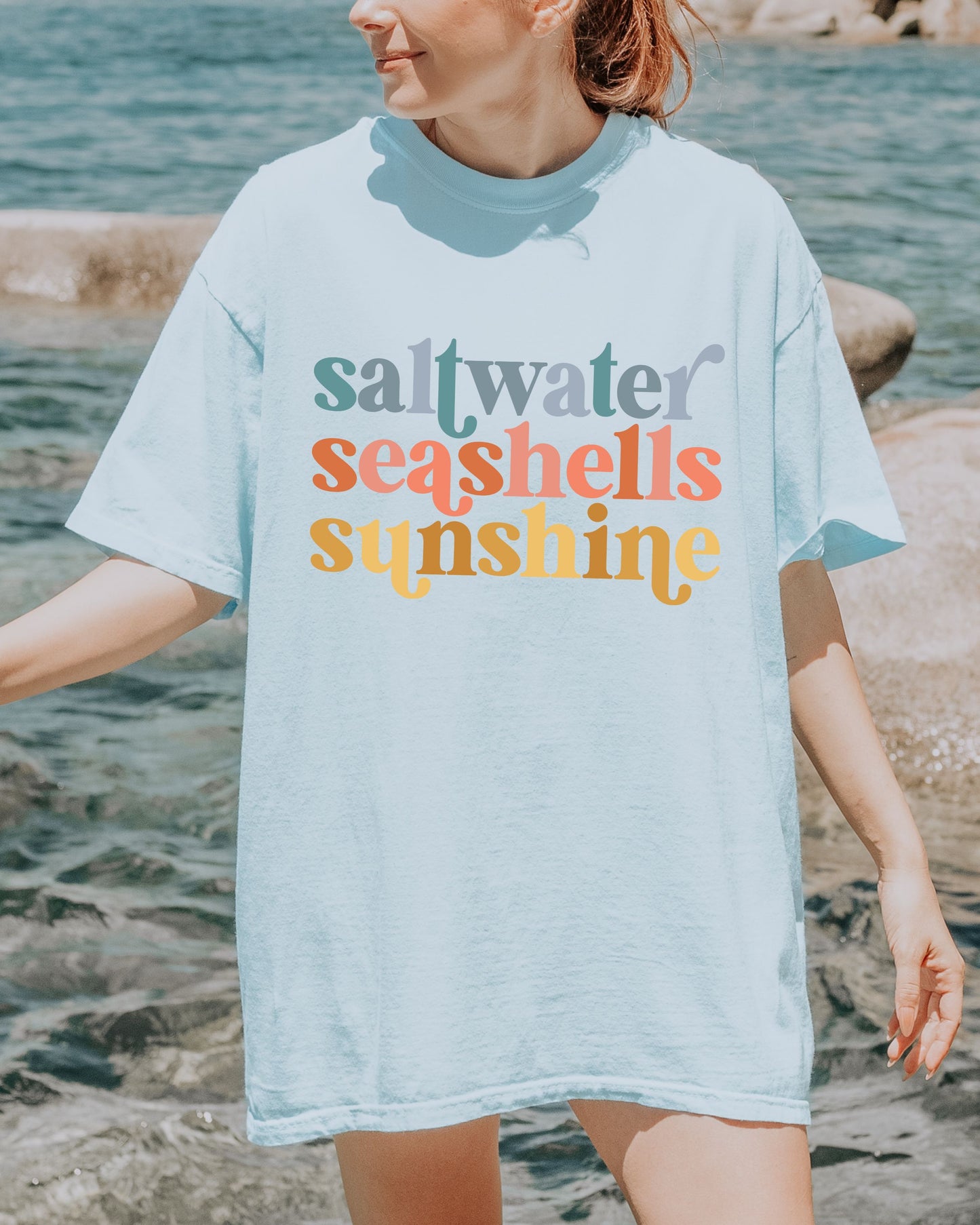 woman wearing beach vibes shirt with saltwater seashells sunshine design