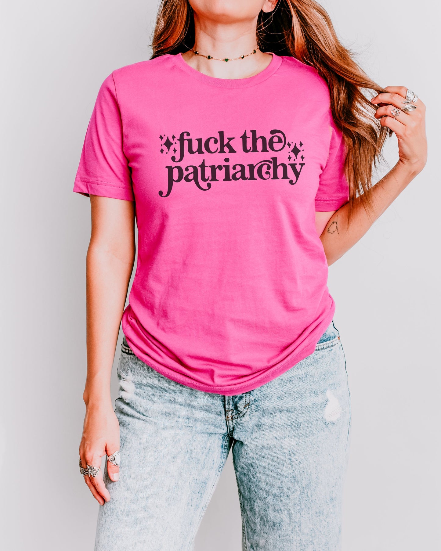 woman wearing a charity pink fuck the patriarchy shirt, feminist graphic tee