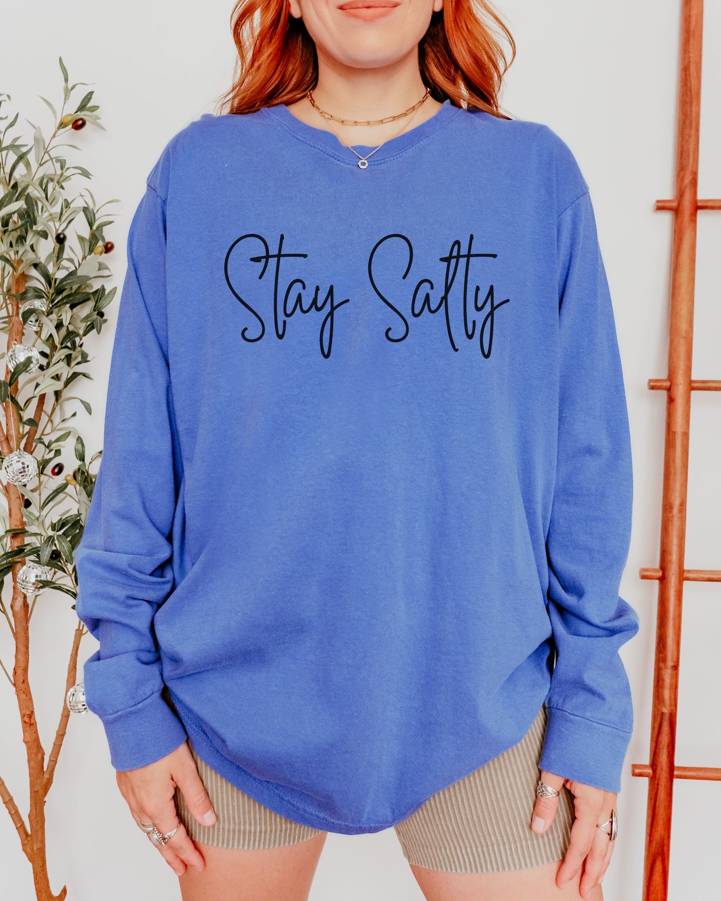 Person wearing a blue sweatshirt with 'Stay Salty' text, standing against a neutral background.