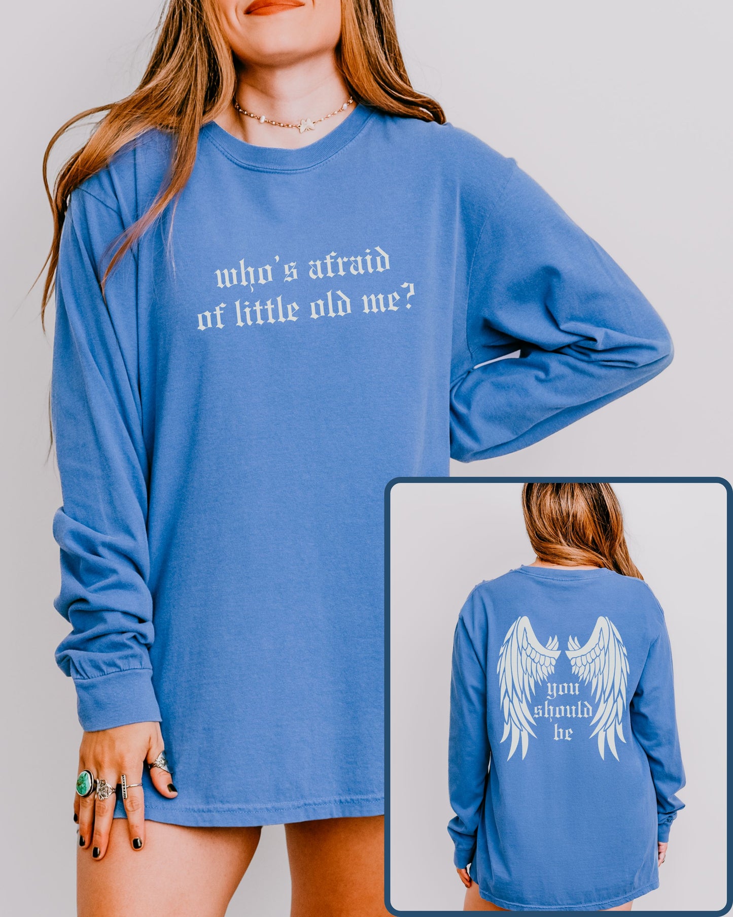 Blue long-sleeve shirt with text 'who's afraid of little old me?' on front, worn by a person.