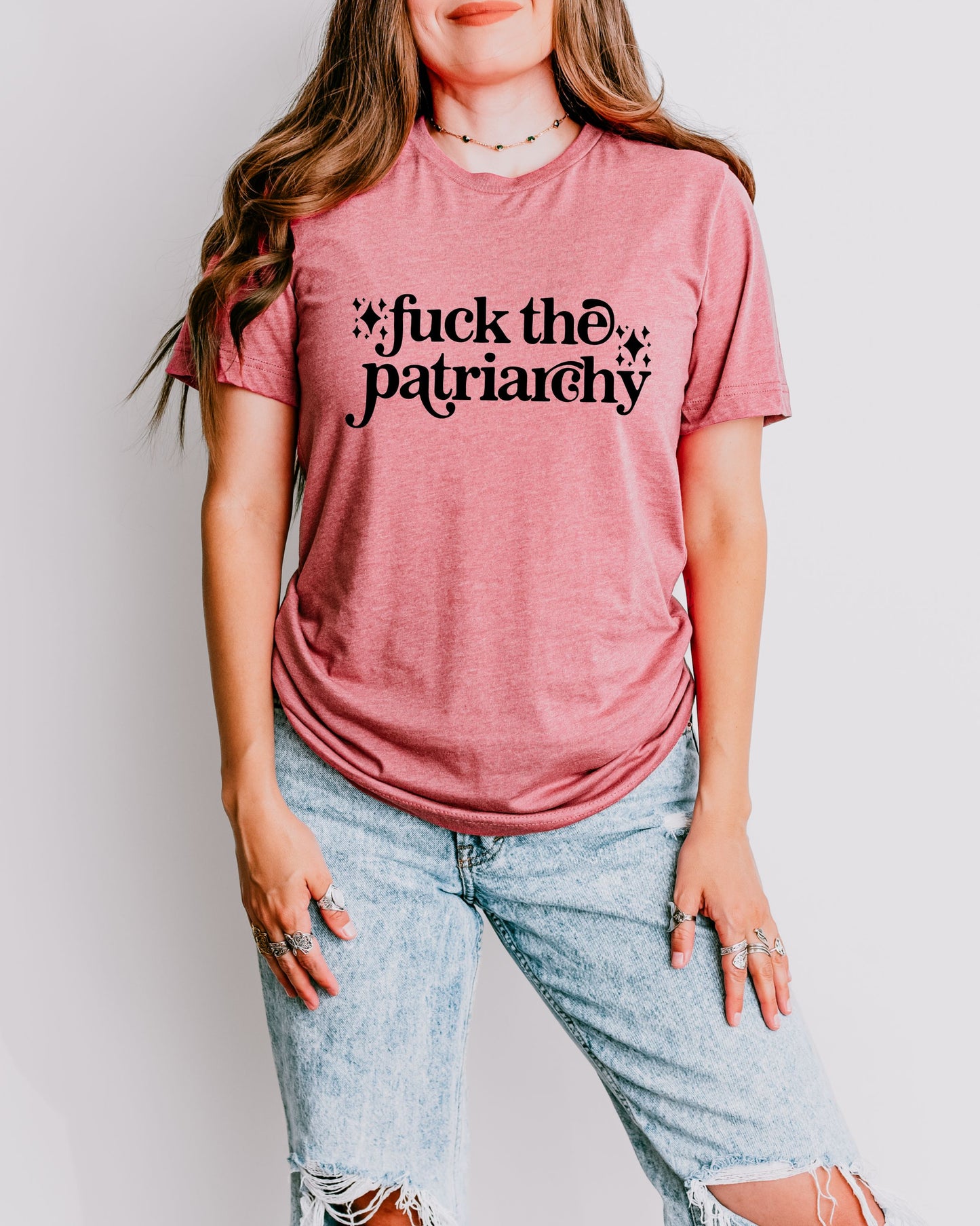 woman wearing a heather mauve fuck the patriarchy shirt, feminist graphic tee