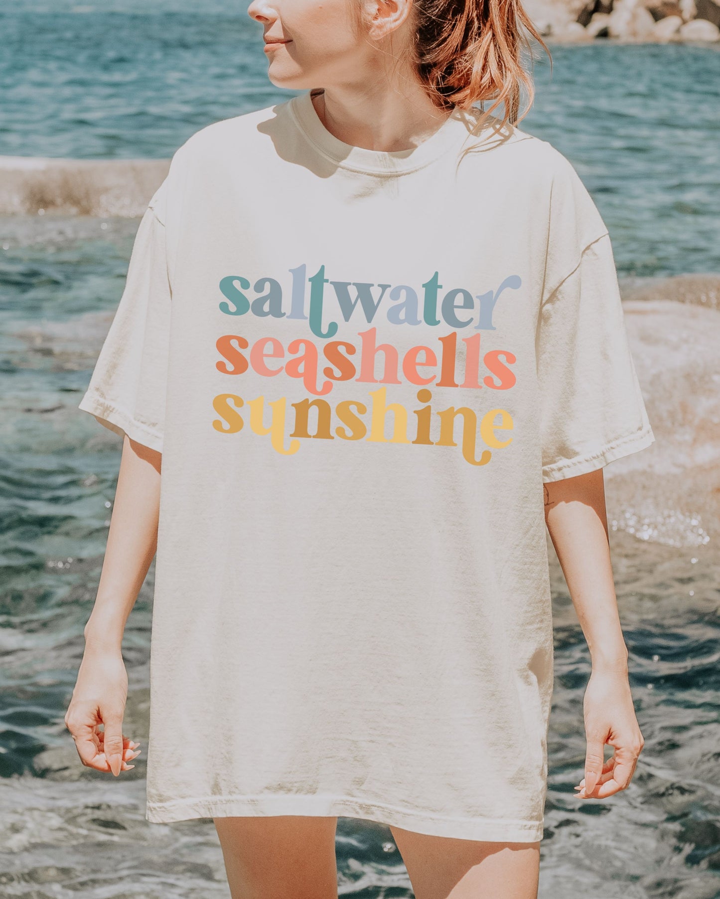 woman wearing beach vibes shirt with saltwater seashells sunshine design