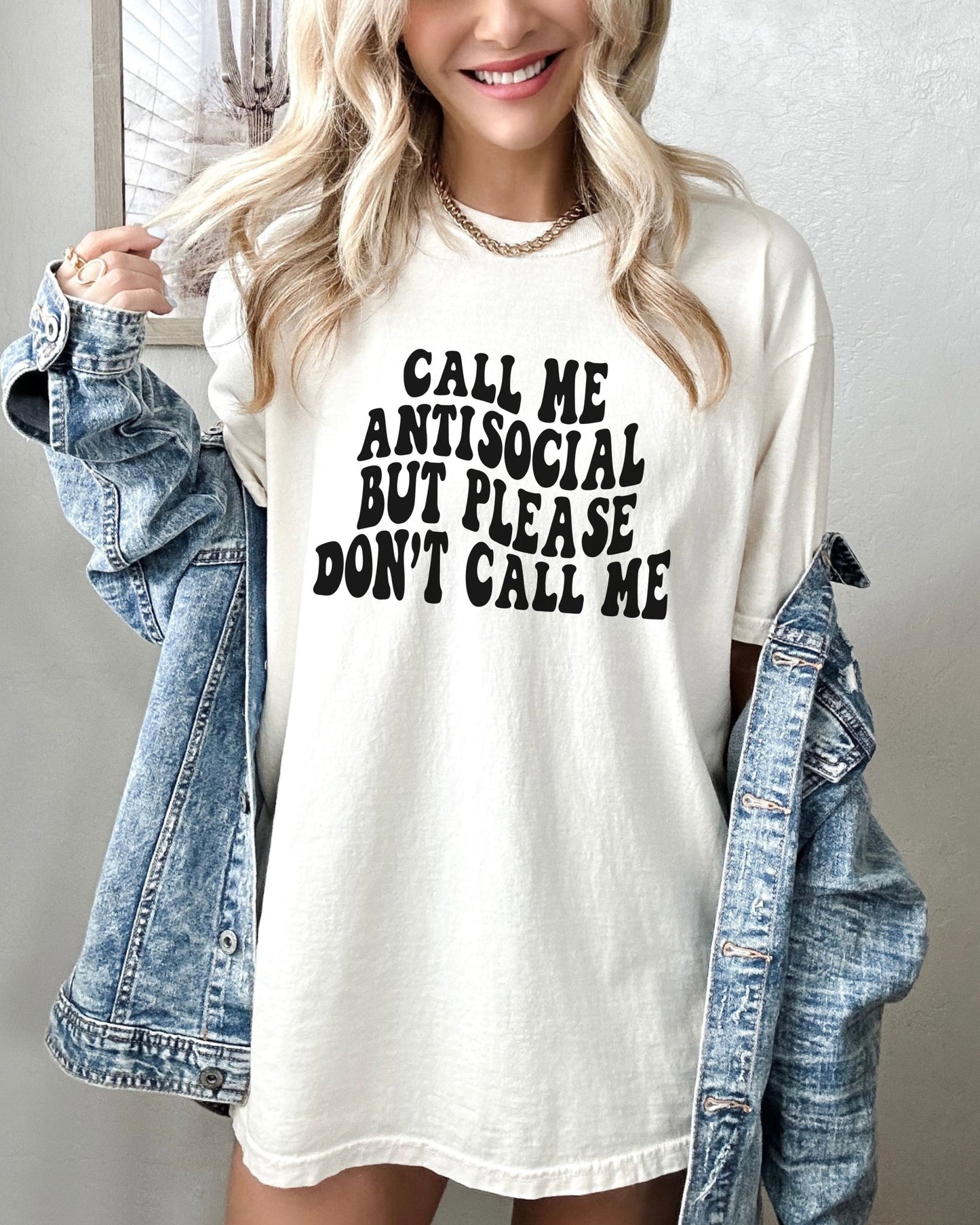 Person wearing a white t-shirt with text and a denim jacket.