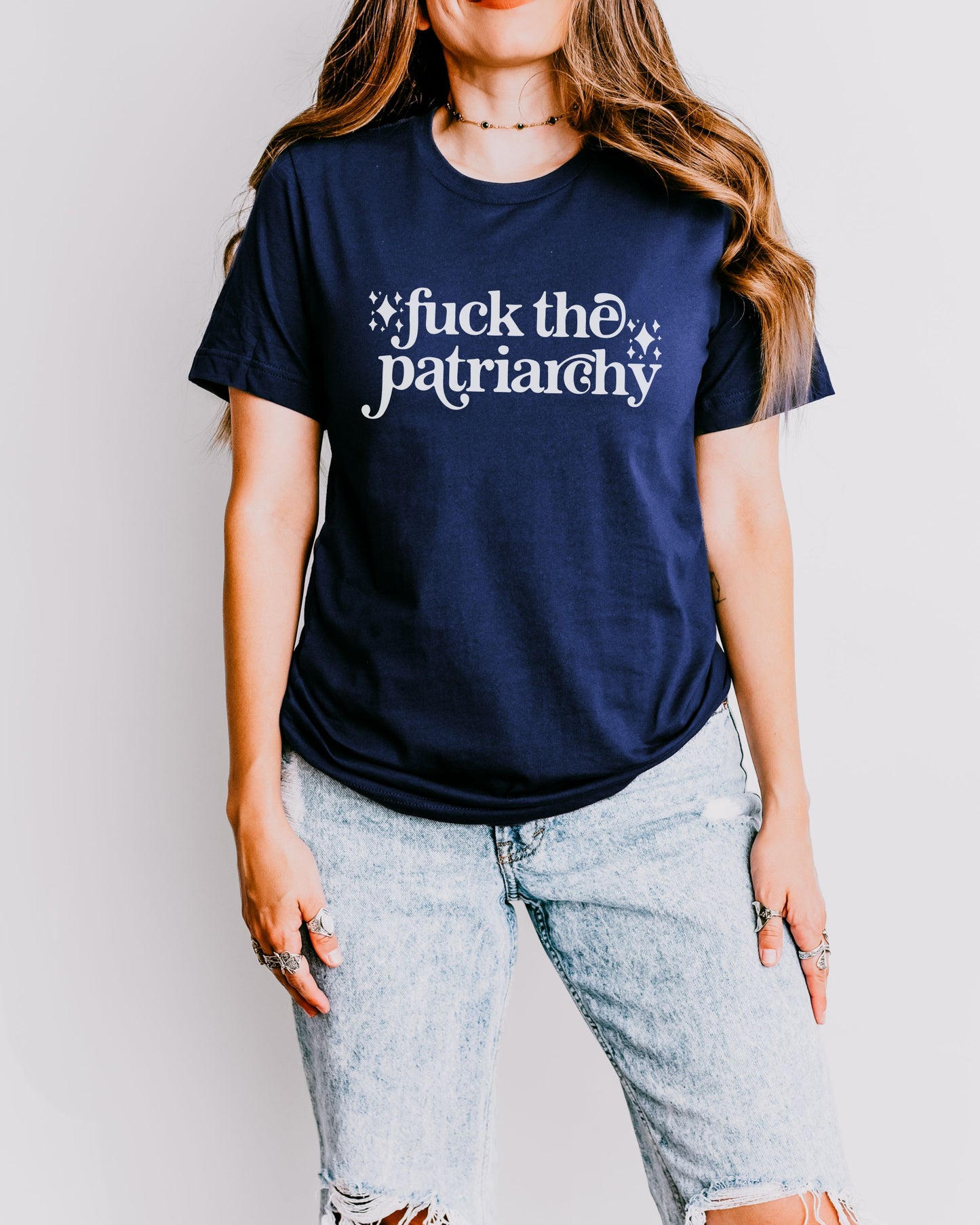 woman wearing a navy fuck the patriarchy shirt, feminist graphic tee