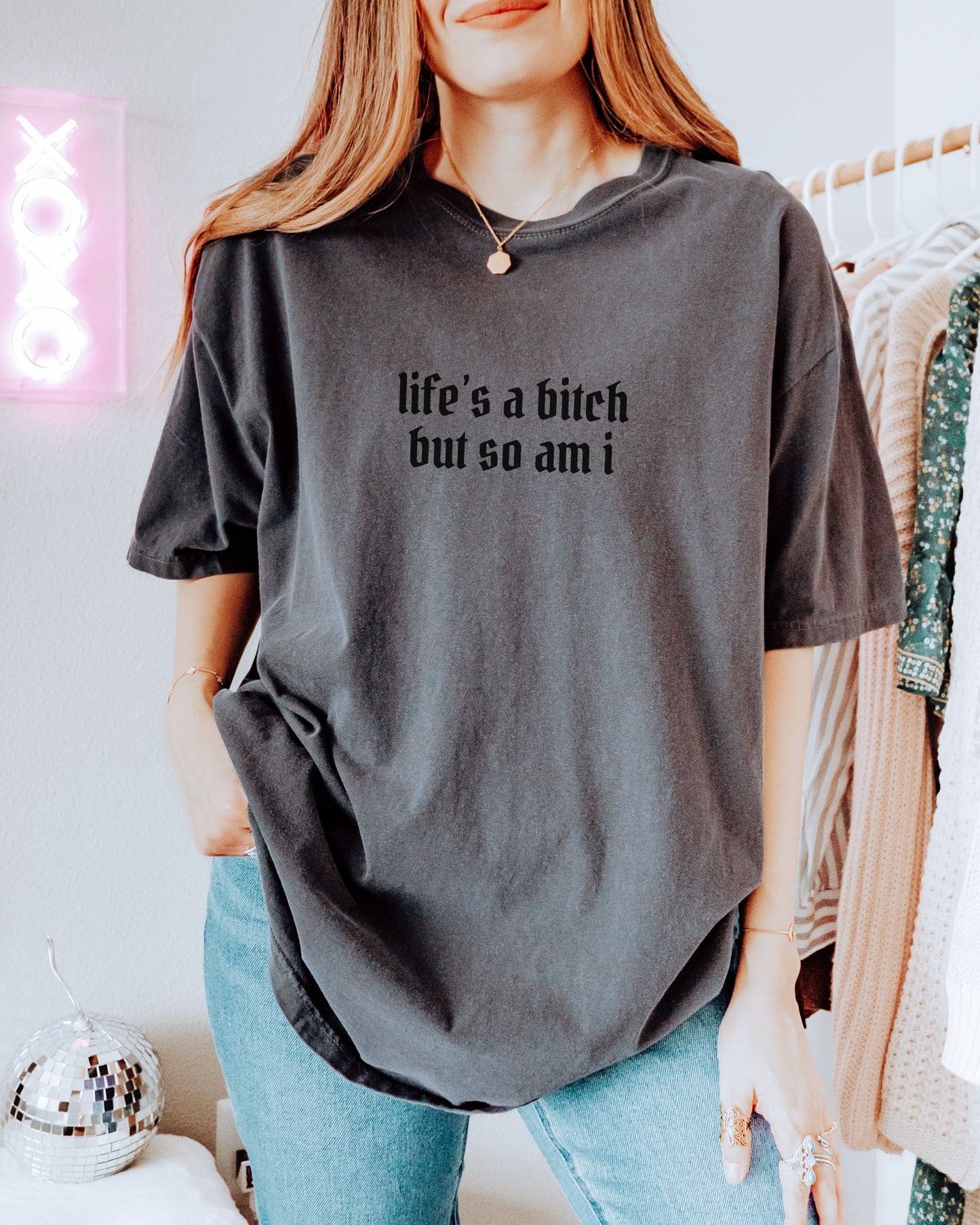 Person wearing a dark gray t-shirt with text in a casual setting