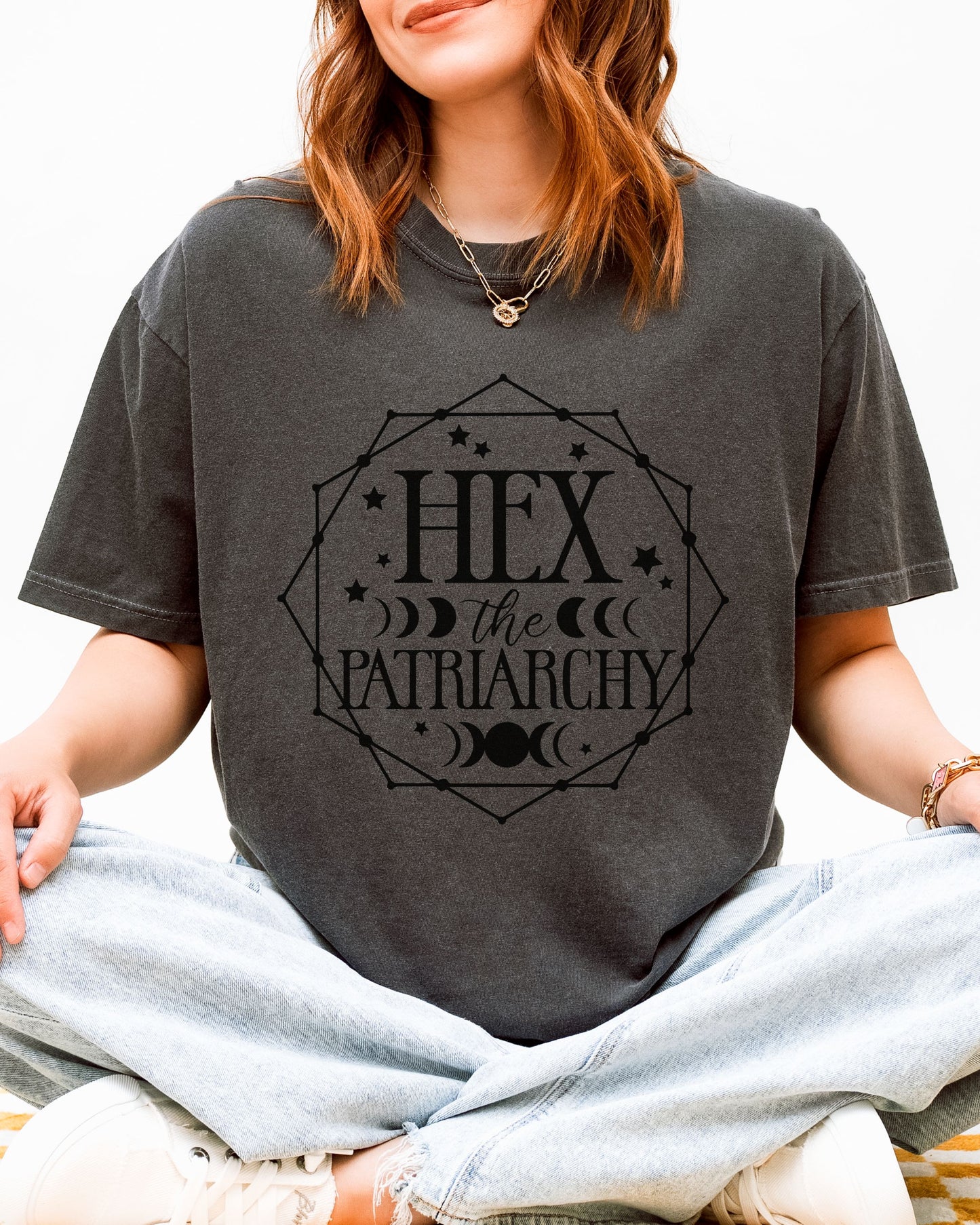 Person wearing a dark gray t-shirt with 'Hex the Patriarchy' text.