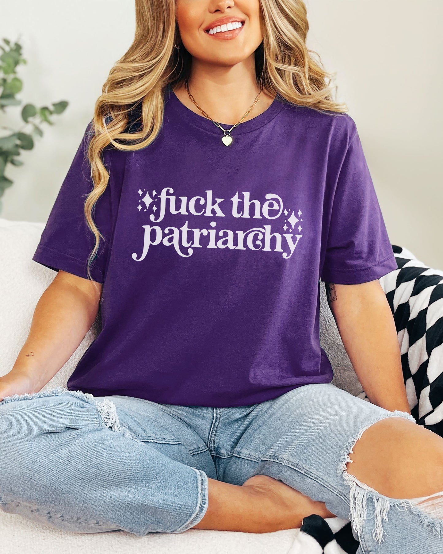 woman wearing a purple fuck the patriarchy shirt, feminist graphic tee