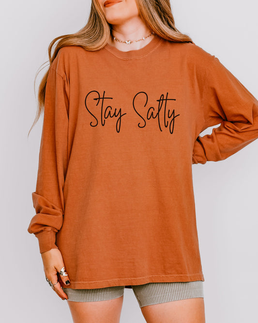 Person wearing a brown long-sleeve shirt with 'Stay Satty' text on a plain background