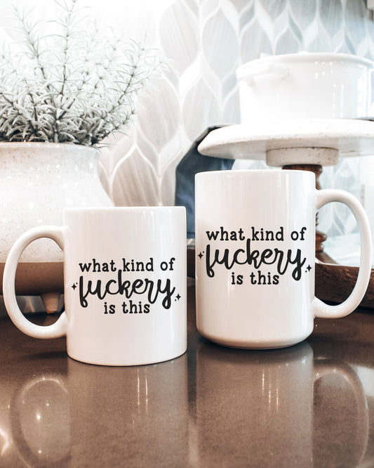 Two white mugs with black text on a reflective surface with decorative background
