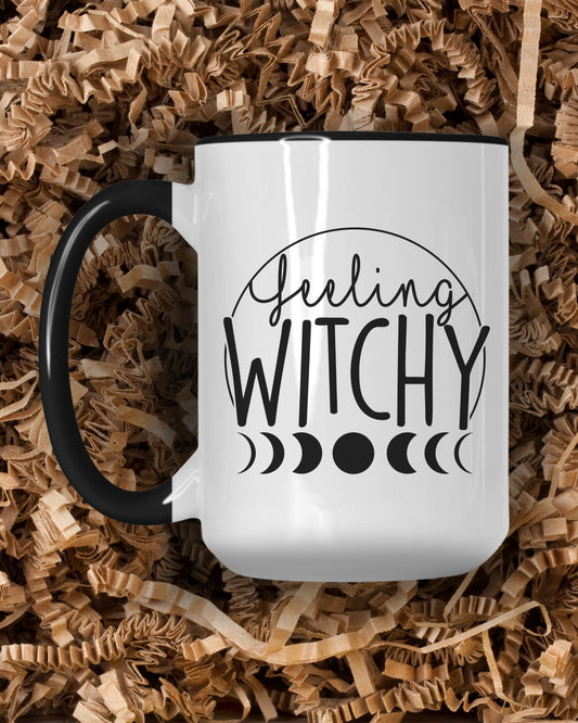 White mug with 'Feeling Witchy' text on a bed of crinkle paper shavings