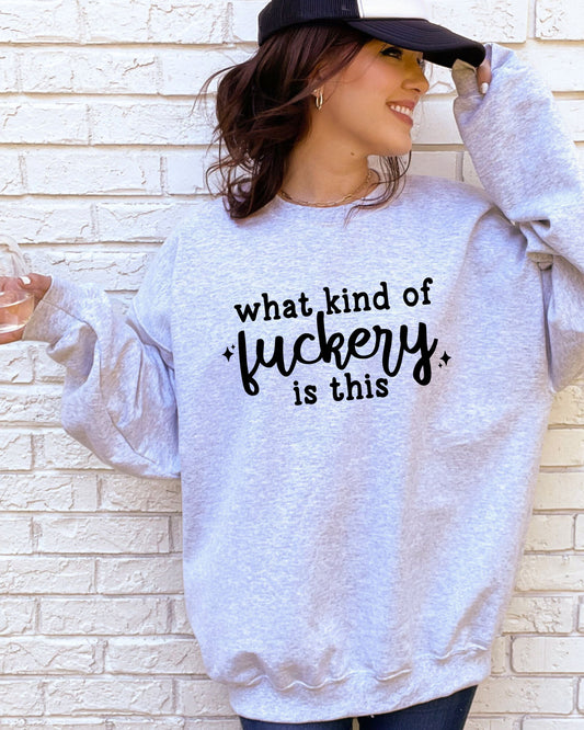 Person wearing a light gray sweatshirt with text, standing against a brick wall.