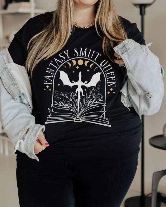 Person wearing a black t-shirt with 'Fantasy Smut Queen' design, wearing a denim jacket.