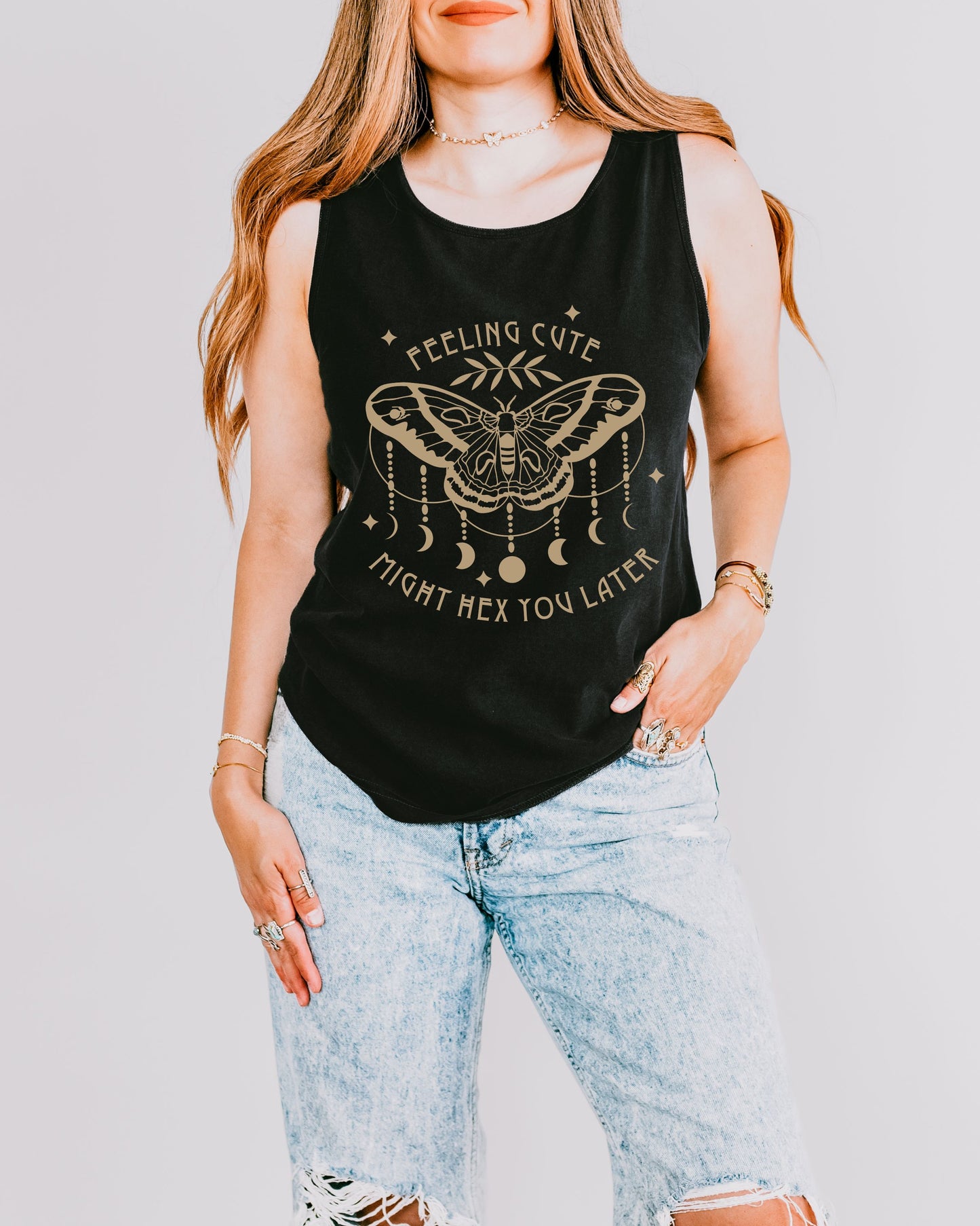 Person wearing a black tank top with a graphic design and text, standing against a plain background.