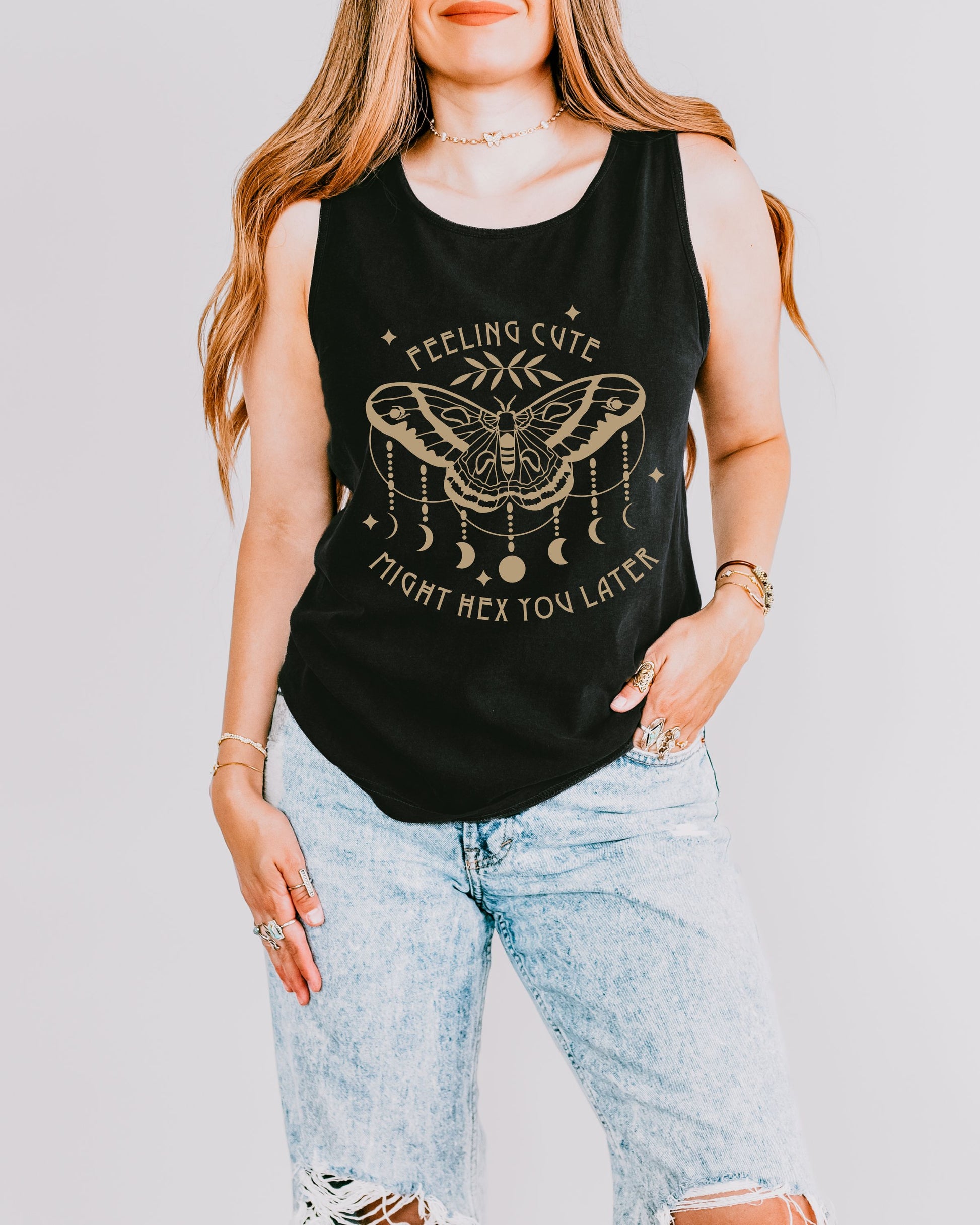 Person wearing a black tank top with a graphic design and text, standing against a plain background.
