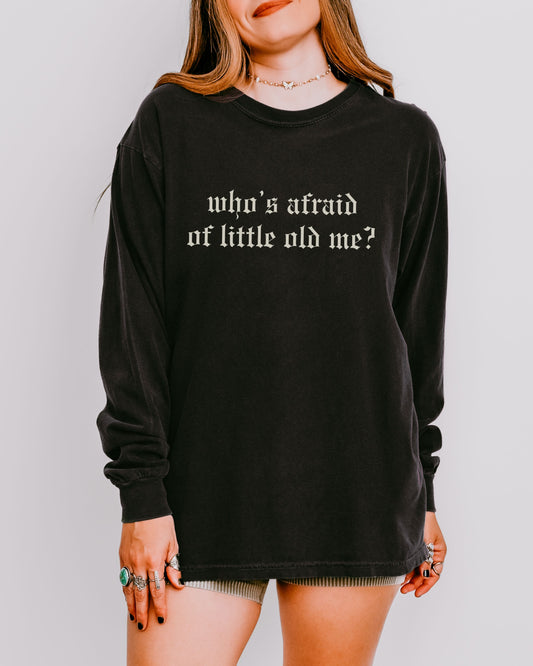 Person wearing a black long-sleeve shirt with text on a plain background