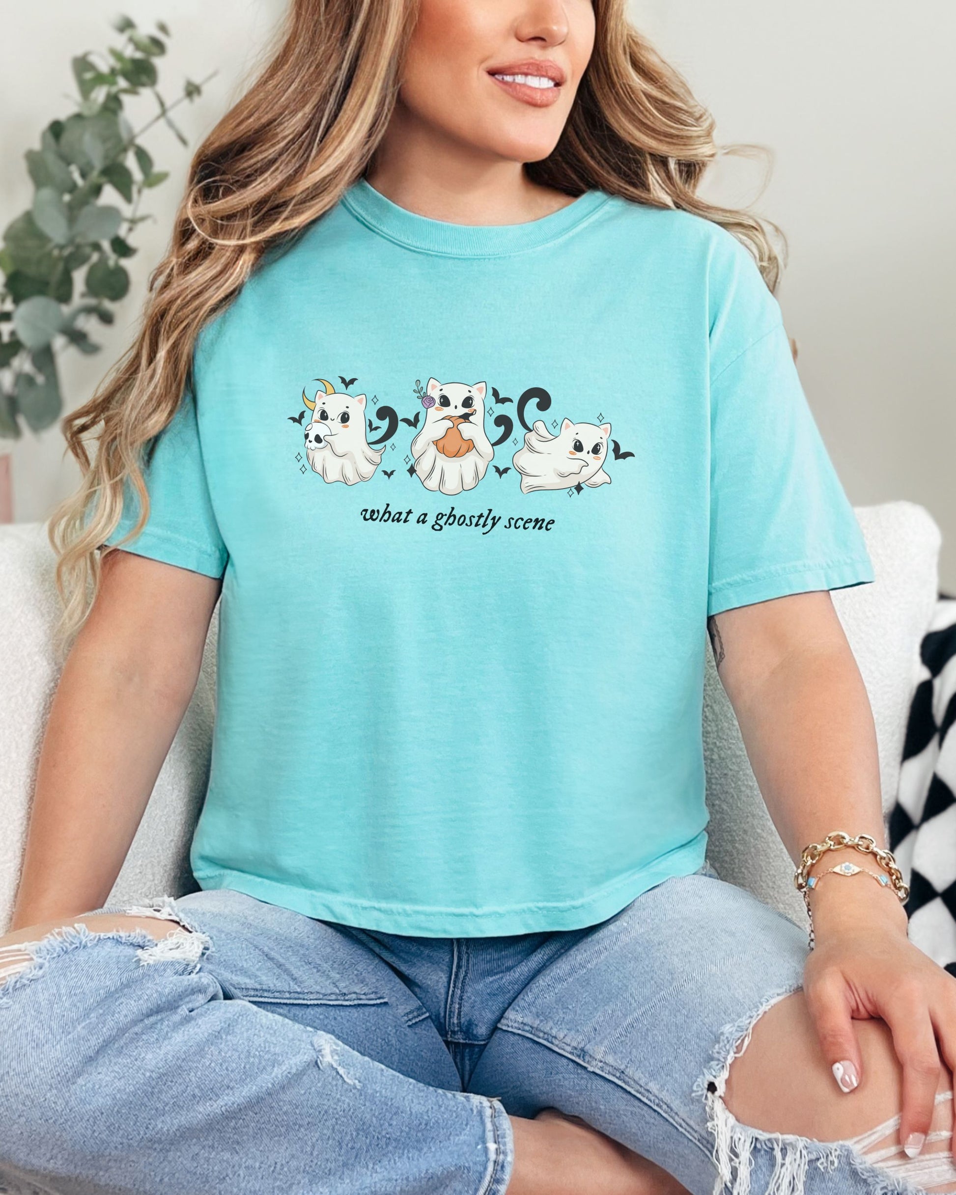 Person wearing a light blue t-shirt with ghost designs and text.