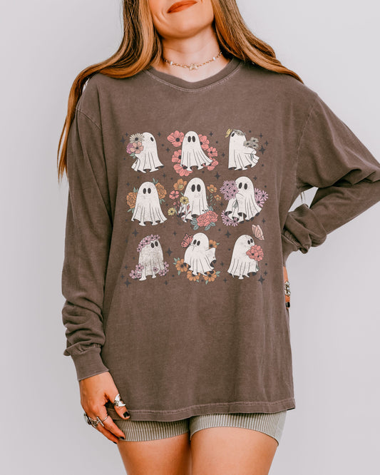 Person wearing a brown long-sleeve shirt with ghost and floral designs on a plain background