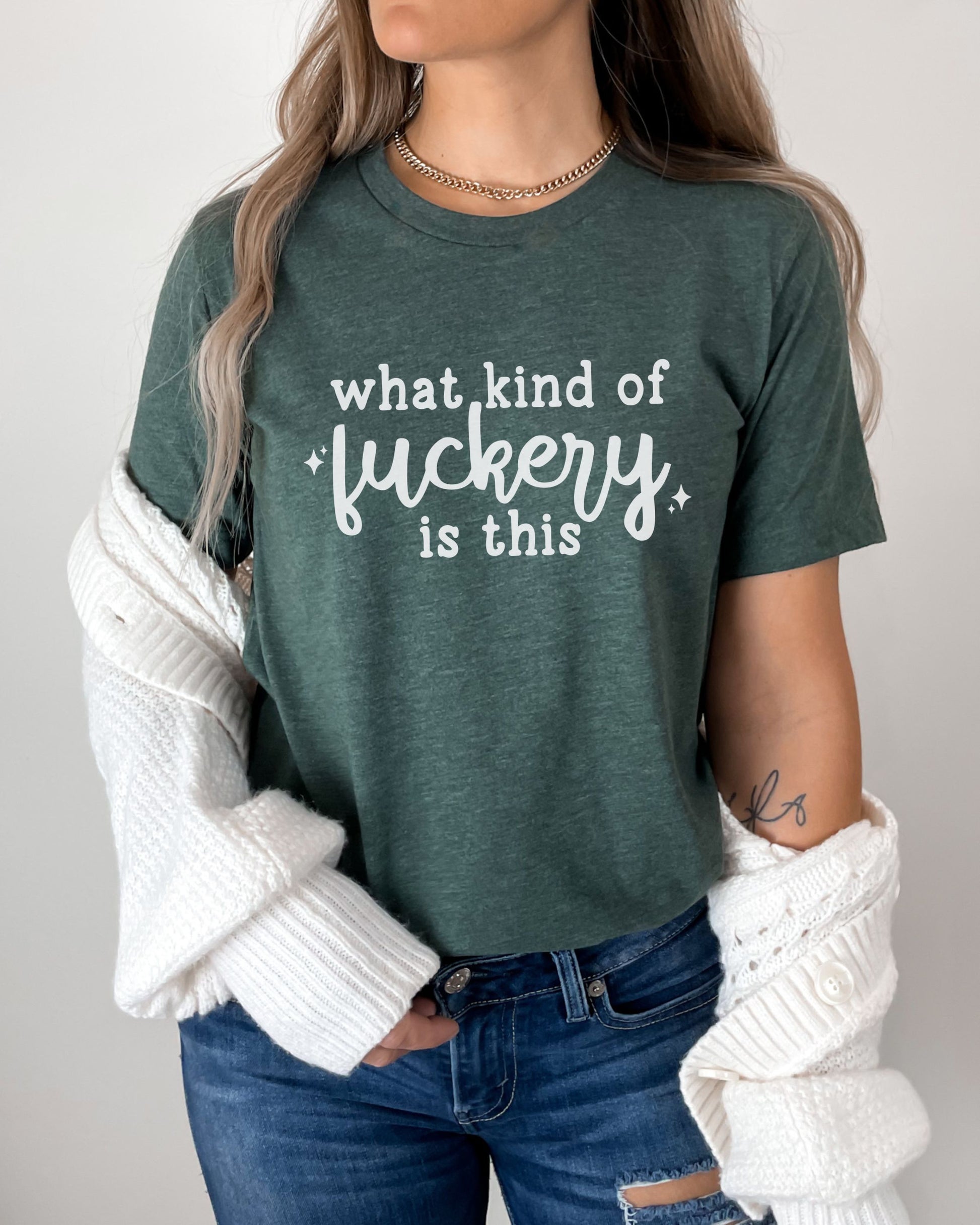 Person wearing a green t-shirt with text, white sweater, and jeans on a plain background
