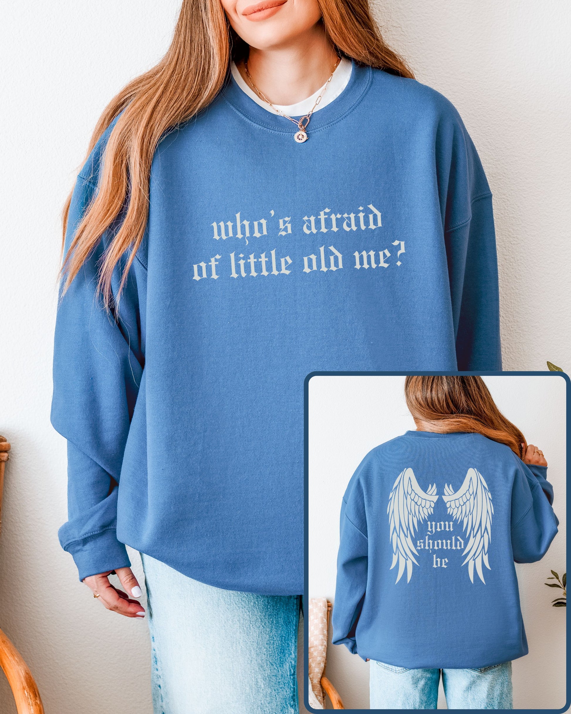 Blue sweatshirt with text 'who's afraid of little old me?' worn by a person, with a close-up of the back showing 'you should be'.