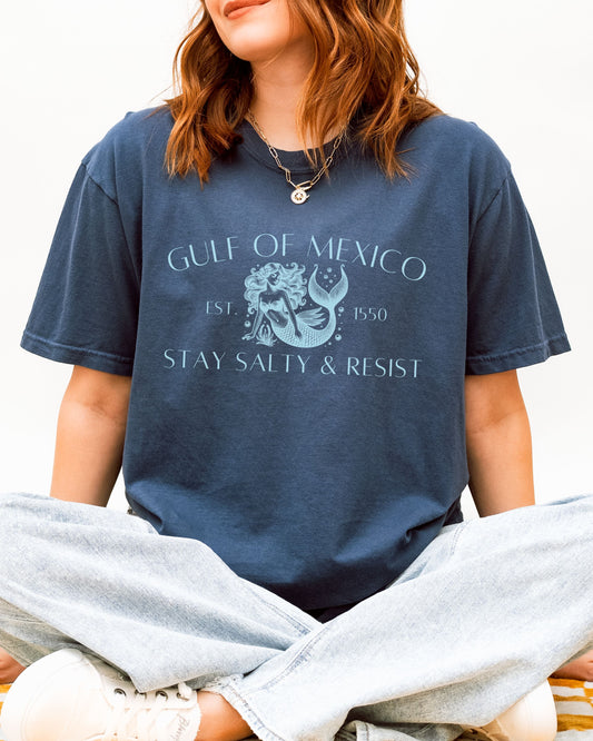 Person wearing a navy blue t-shirt with 'Gulf of Mexico' and 'Stay Salty & Resist' text.