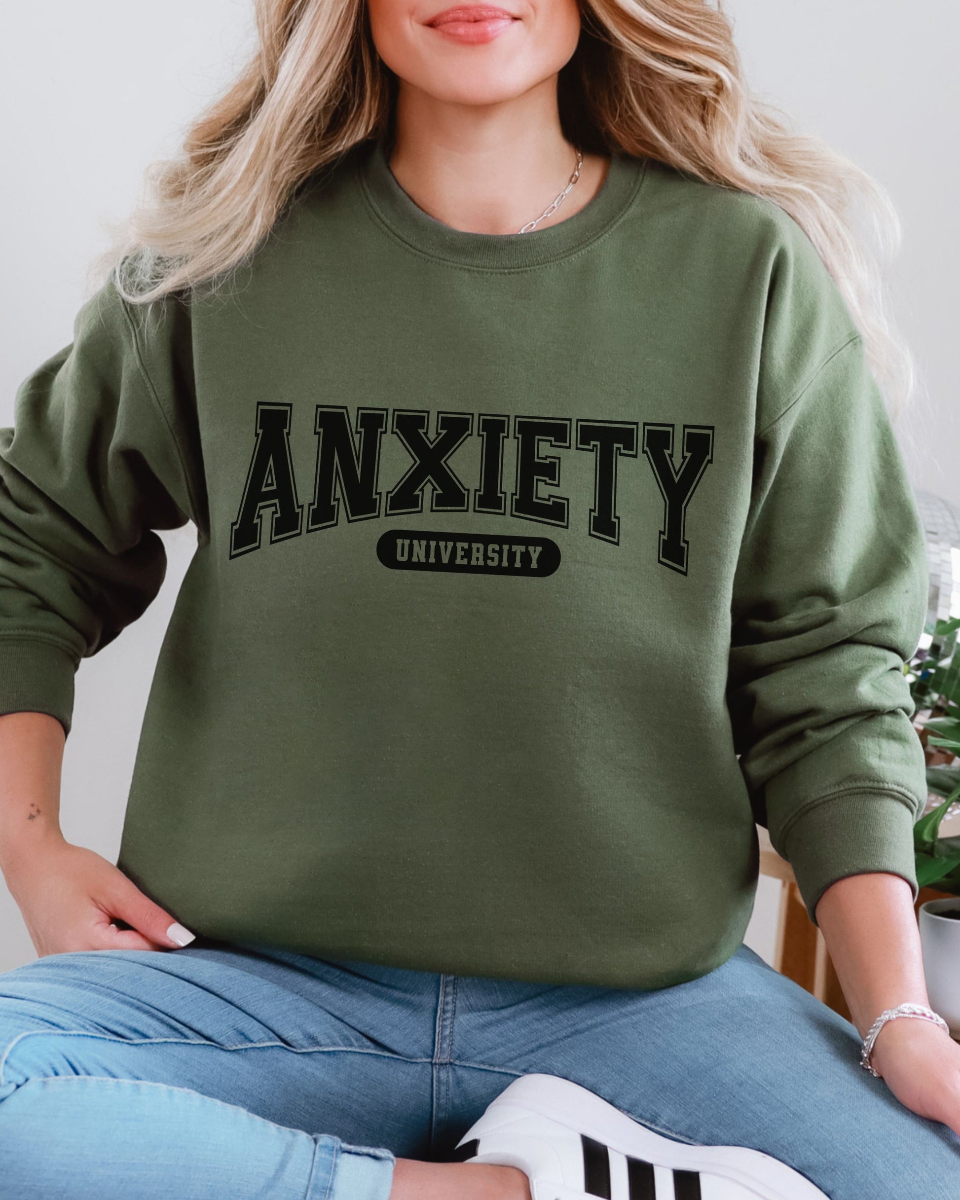 Person wearing a green sweatshirt with 'ANXIETY UNIVERSITY' text.