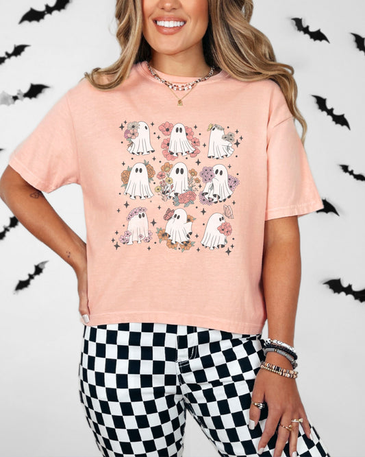 Woman wearing a pink t-shirt with ghost designs on a white background with bats.
