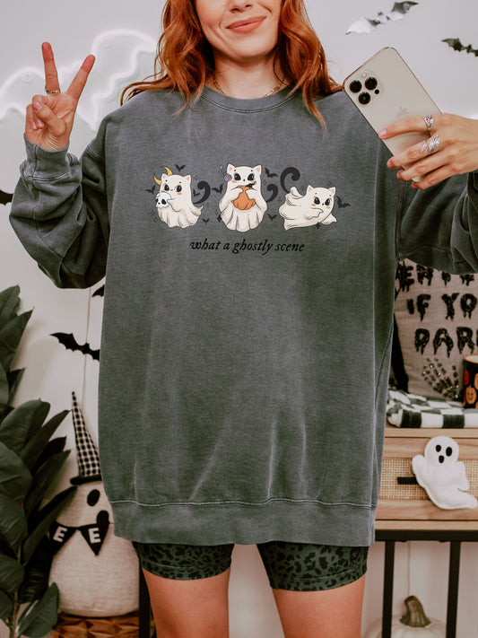 Person wearing a dark green sweatshirt with ghost designs and text, taking a selfie.