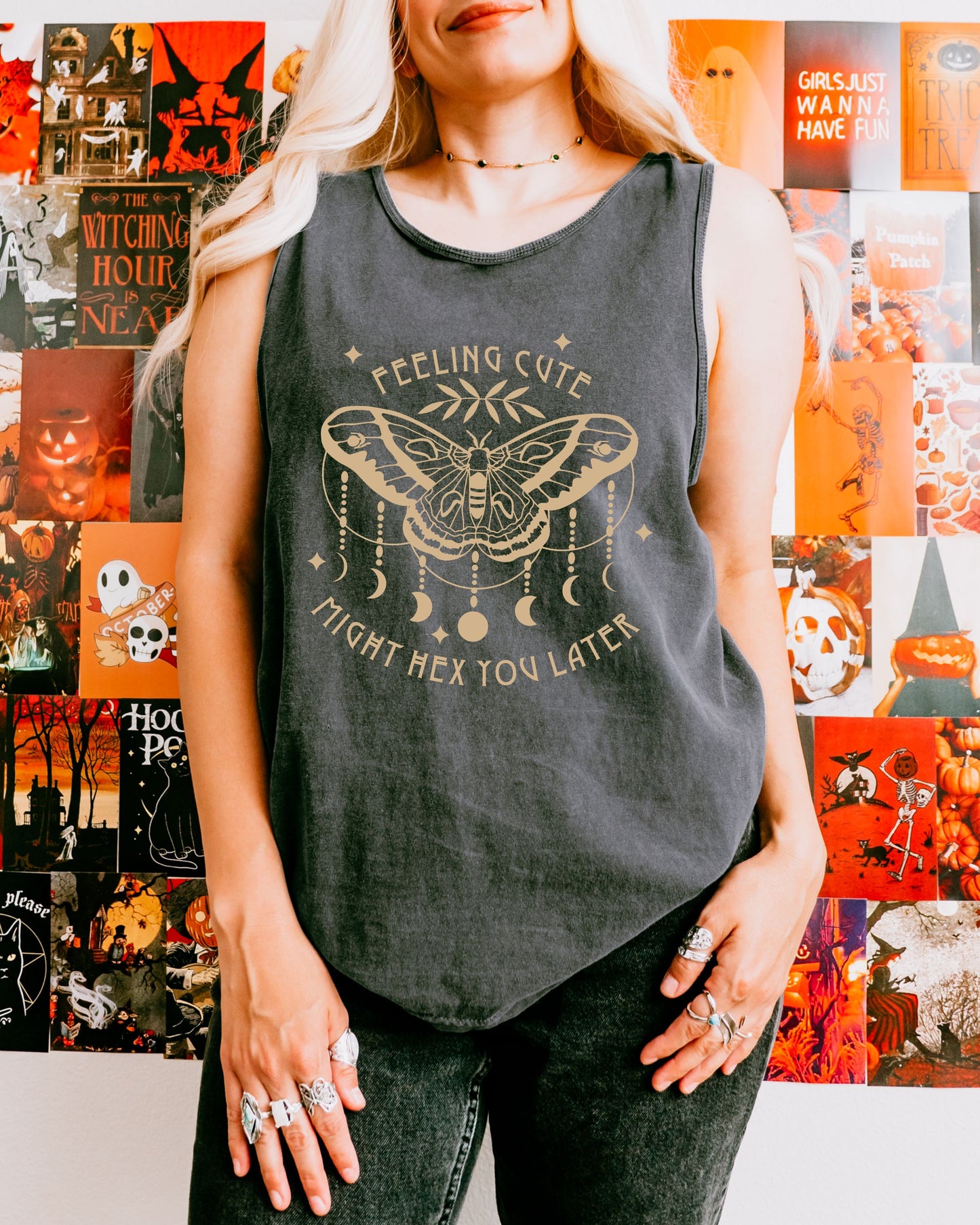 Person wearing a gray tank top with a graphic design in front of a colorful Halloween-themed wall.