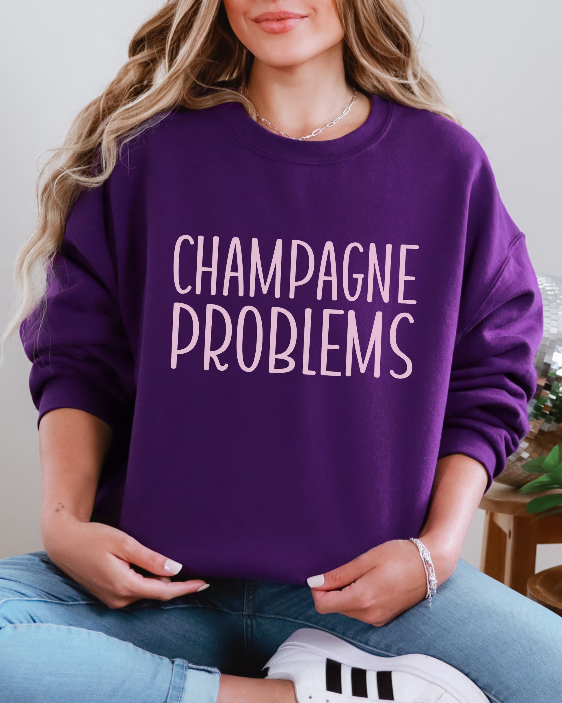 Person wearing a purple sweatshirt with 'CHAMPAGNE PROBLEMS' text.