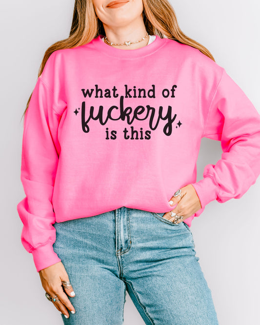 Person wearing a pink sweatshirt with text and blue jeans on a plain background
