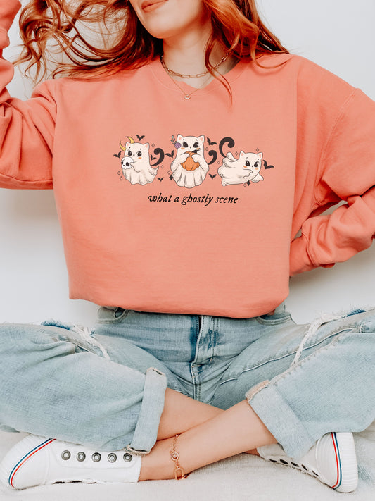 Person wearing a coral sweatshirt with ghost-themed design and text.