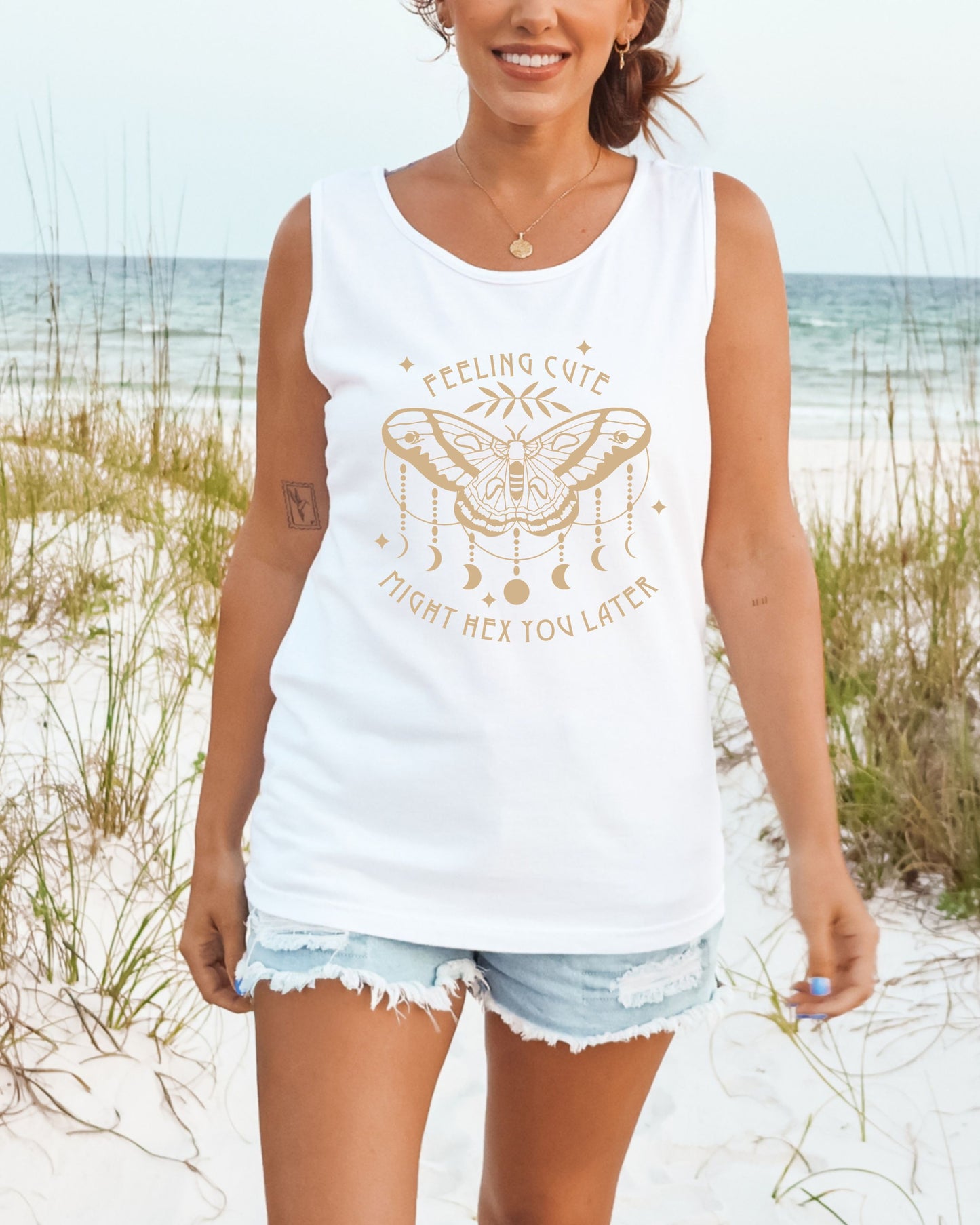 Woman wearing a white tank top with a graphic design on a beach